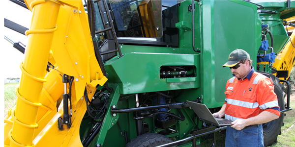 Cummins employee with AX7500 sugar cane harvester